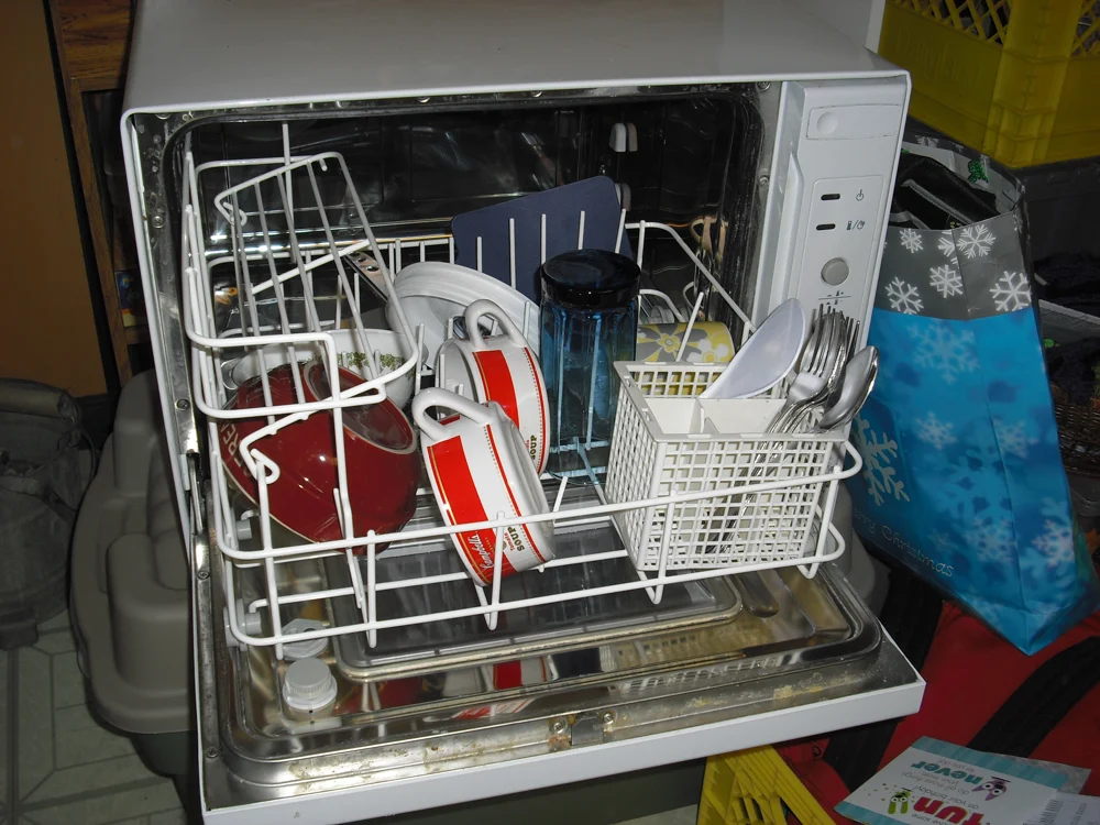 A real countertop dishwasher with its loaded rack pulled out